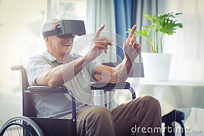 Happy senior man on wheelchair using VR headset Stock Photo