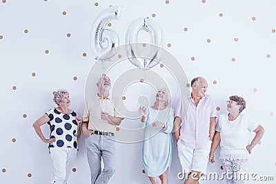 Happy senior man and woman holding silver balloons. Stock Photo