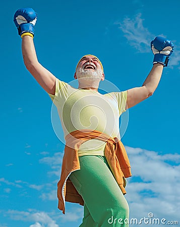 Happy Senior sportive man in boxing stance doing exercises with boxing gloves. Boxing. Active leisure. Fighter. Senior Stock Photo