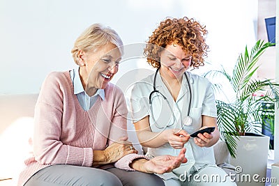 Happy senior woman having her blood sugar measured in a nursing home by her caregiver. Happy nurse measuring blood sugar of a Stock Photo