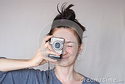 Happy shaggy middle aged casual woman taking photo with the camera social active and smiling on grey wall background Stock Photo