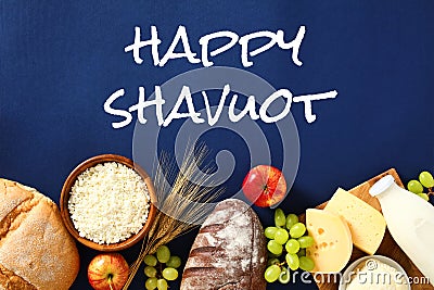 Happy Shavuot concept with dairy products and fruits on blue background Stock Photo