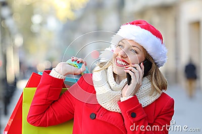 Happy shopper talking on phone on christmas Stock Photo