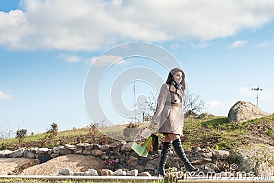 Happy Shopping: Woman walking under blue sky Stock Photo