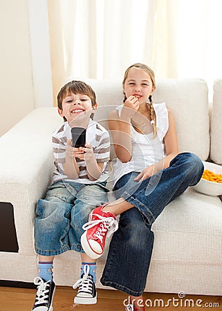 Happy siblings watching TV Stock Photo