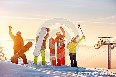 Happy skiers and snowboarders at sunset mountain top Stock Photo