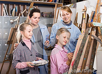 Skillful young students looking at progress of fellow student during painting class Stock Photo