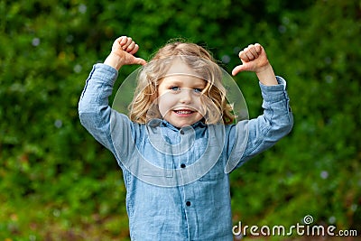 Happy small child with long blond hair and saying OK Stock Photo