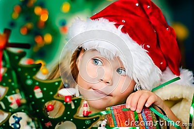 Happy small girl in Santa's hat has a Christmas Stock Photo