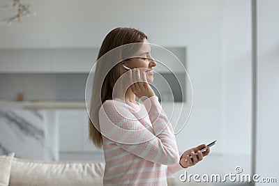 Happy smartphone user listening to ambient music from wireless earphone Stock Photo