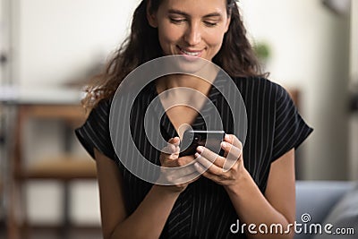 Happy smartphone user sitting on couch with gadget Stock Photo