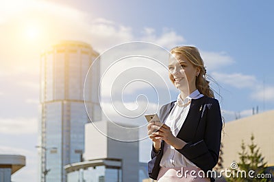 Happy smiling businesswoman receiving good news in message. Business lady walking street during break Stock Photo