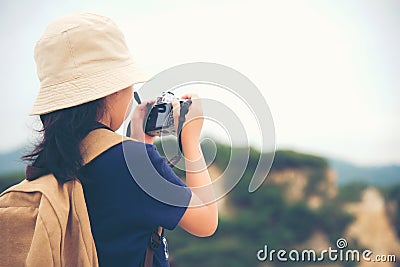 Happy smiling caucasian children asian girl backpack and holding camera for take a photo check in on mountain. Stock Photo