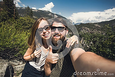 Happy smiling couple of students in love take selfie self-portrait while hiking in Yosemite National Park, California Stock Photo