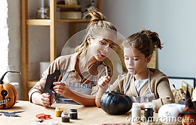 Happy smiling family mother and daughter making Halloween home decorations together Stock Photo