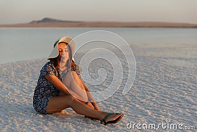 Happy smiling girl enjoying the sunset, closed her eyes to pleasure, sit on salt Stock Photo