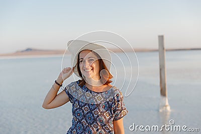 Happy smiling girl in white hat enjoying sun, expanse of Bascunchak salt lake Stock Photo