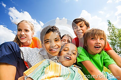 Happy smiling kids sitting in a hug close outside Stock Photo