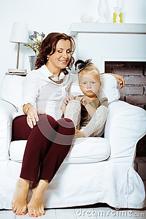Happy smiling mother with little cute daughter at home interior, casual look modern real family, lifestyle people Stock Photo