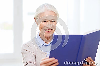 Happy smiling senior woman reading book at home Stock Photo
