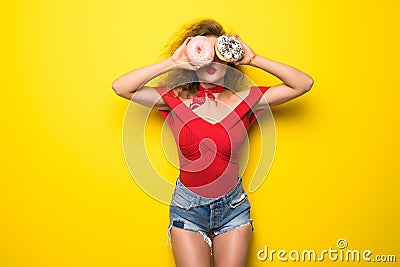 Happy smiling stylish woman with donutes on yellow background Stock Photo