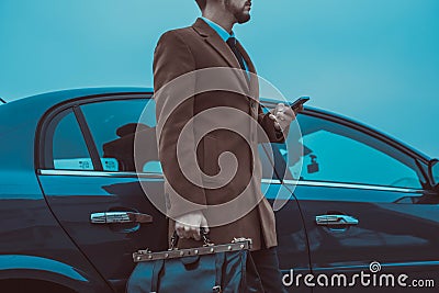 Happy smiling successful businessman standing near new car, outdoors Stock Photo