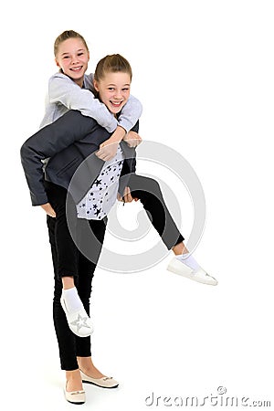 Happy Smiling Teen Girl Piggy Backing her Twin Sister Stock Photo