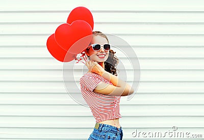 Happy smiling woman with air balloons heart shape having fun over white Stock Photo