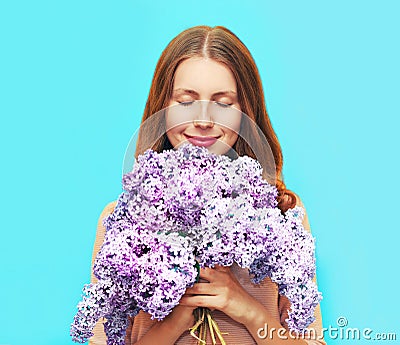 Happy smiling woman enjoying smell of bouquet lilac flowers Stock Photo