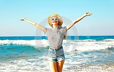 Happy smiling woman enjoys the fresh smell of the sea on a summer day Stock Photo