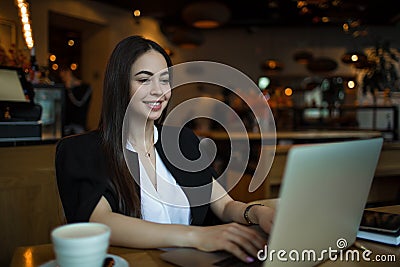 Happy smiling woman in fashionable clothes having online training course on laptop computer Stock Photo