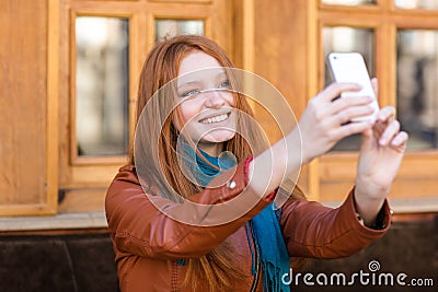 Happy smiling woman with long red hair making selfie Stock Photo