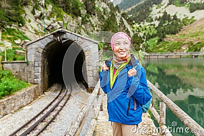 Smiling woman traveling by train on most picturesque railway road in Nuria Valley in Spain Stock Photo