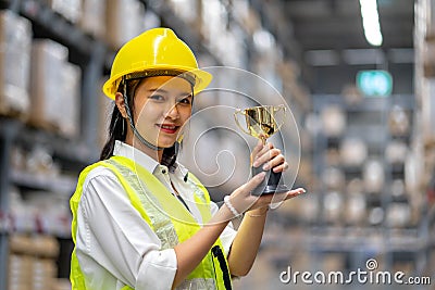 Happy smiling woman warehouse Staff holding a trophy after being selected as an outstanding employee Stock Photo