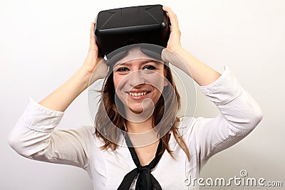 Happy, smiling woman in a white shirt, wearing Oculus Rift VR Virtual reality 3D headset, taking it off or putting it on Editorial Stock Photo