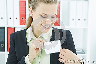 Happy smiling young business woman wearing blank badge. Stock Photo