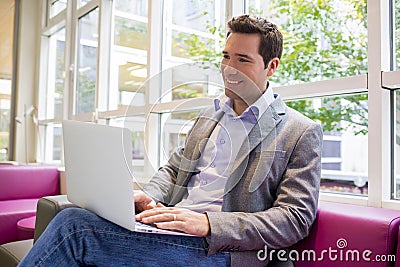 Happy smiling young Businessman working with Laptop on sofa Stock Photo