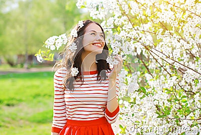 Happy smiling young woman in flowering spring garden Stock Photo