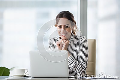 Happy smiling young woman looking at laptop screen. Stock Photo