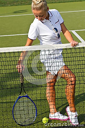 Happy sports girl stands with racket on court at sunny summer day Stock Photo