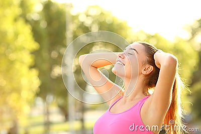 Happy sportswoman breathing fresh air in a park Stock Photo