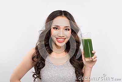 Happy sportswoman showing healthy fruit and vegetables drink. Stock Photo