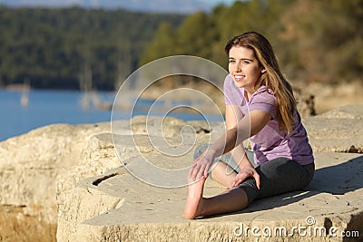 Happy sportswoman stretching leg in nature Stock Photo