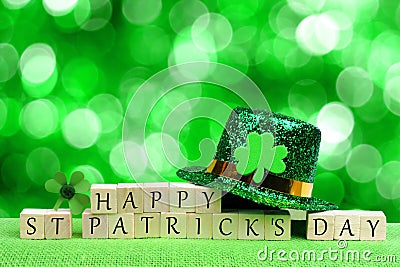 Happy St Patricks Day blocks, leprechaun hat over twinkling green Stock Photo