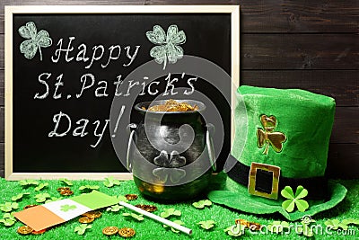 Happy St. Patricks Day chalk lettering on blackboard, leprechauns cast iron pot full of gold and hat, clover leaves, Irish flag, Stock Photo