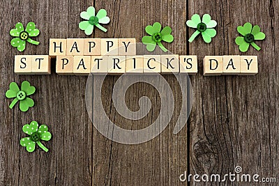 Happy St Patricks Day wooden blocks with shamrocks over wood Stock Photo