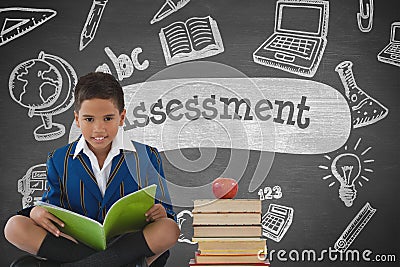 Happy student boy at table reading against grey blackboard with assessment text and education and sc Stock Photo