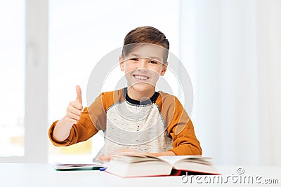 Happy student boy with textbook showing thumbs up Stock Photo