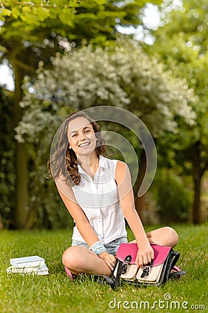 Happy student girl sitting grass open schoolbag Stock Photo