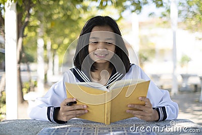 Happy student readding book and sitting at school Stock Photo